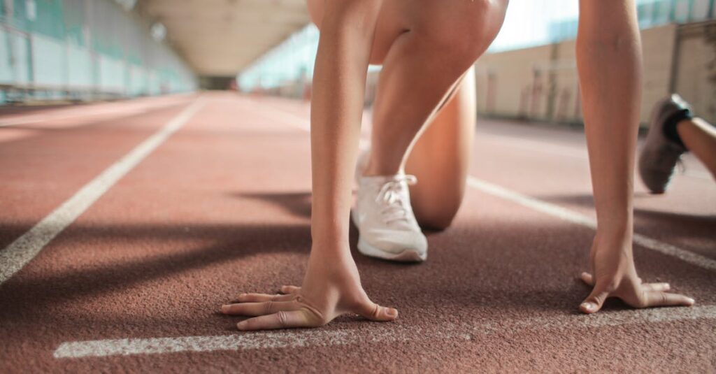 pexels-photo-3763867-3763867 Focused female athlete in crouch start position preparing to sprint on an indoor track.